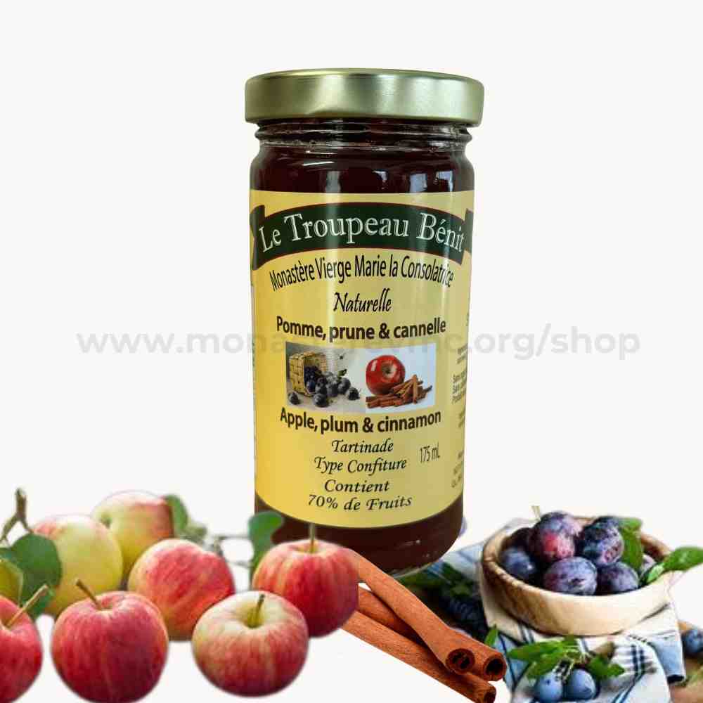 Jar of Le Troupeau Bénin jam with apples, plums, and cinnamon sticks on a white background