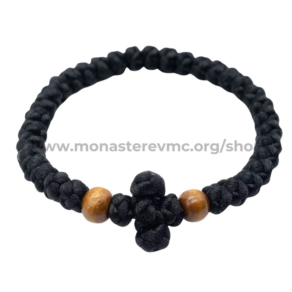 Black braided bracelet with wooden beads on a white background