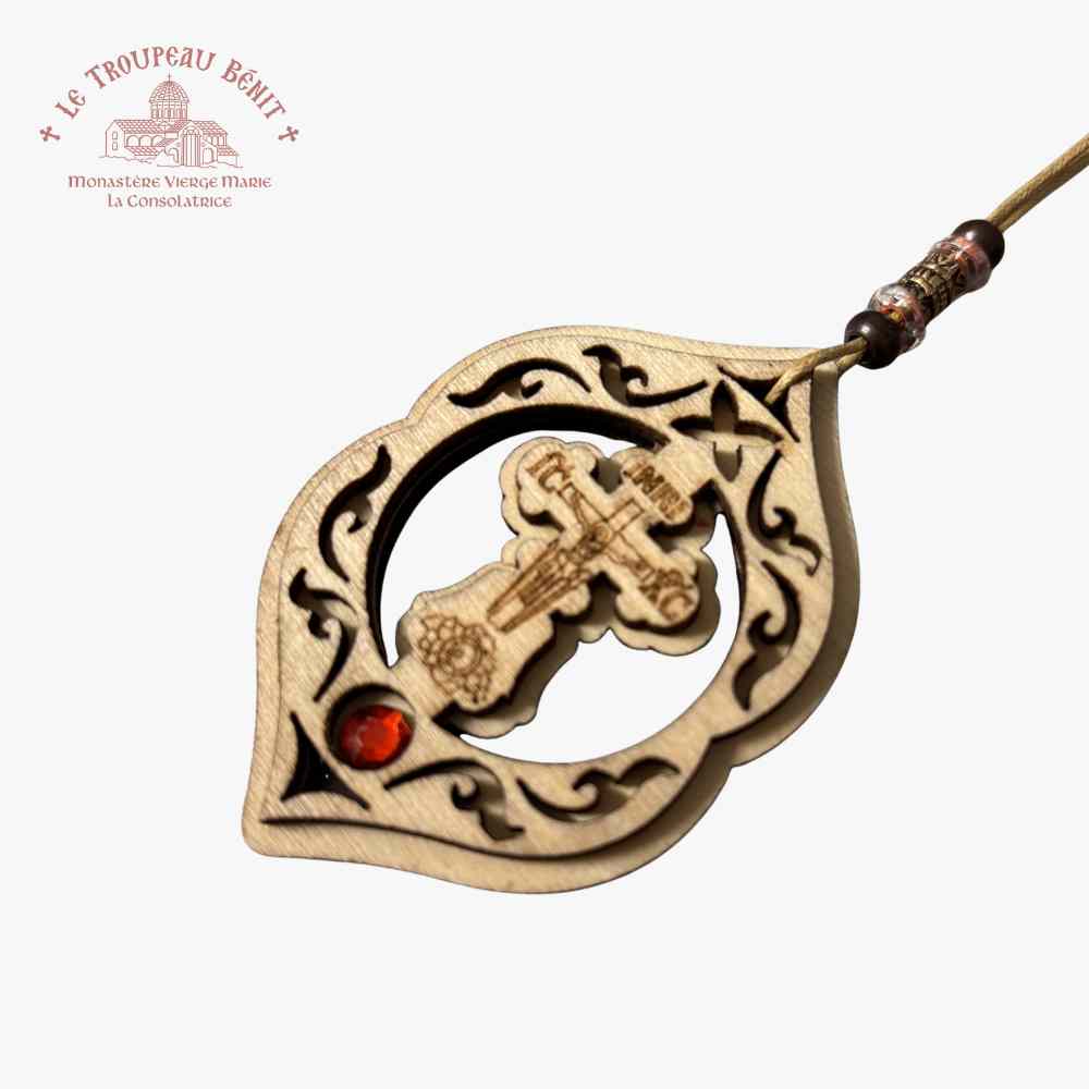 Decorative wooden pendant with intricate designs on a white  background with 'Troupeau Benit' logo branding