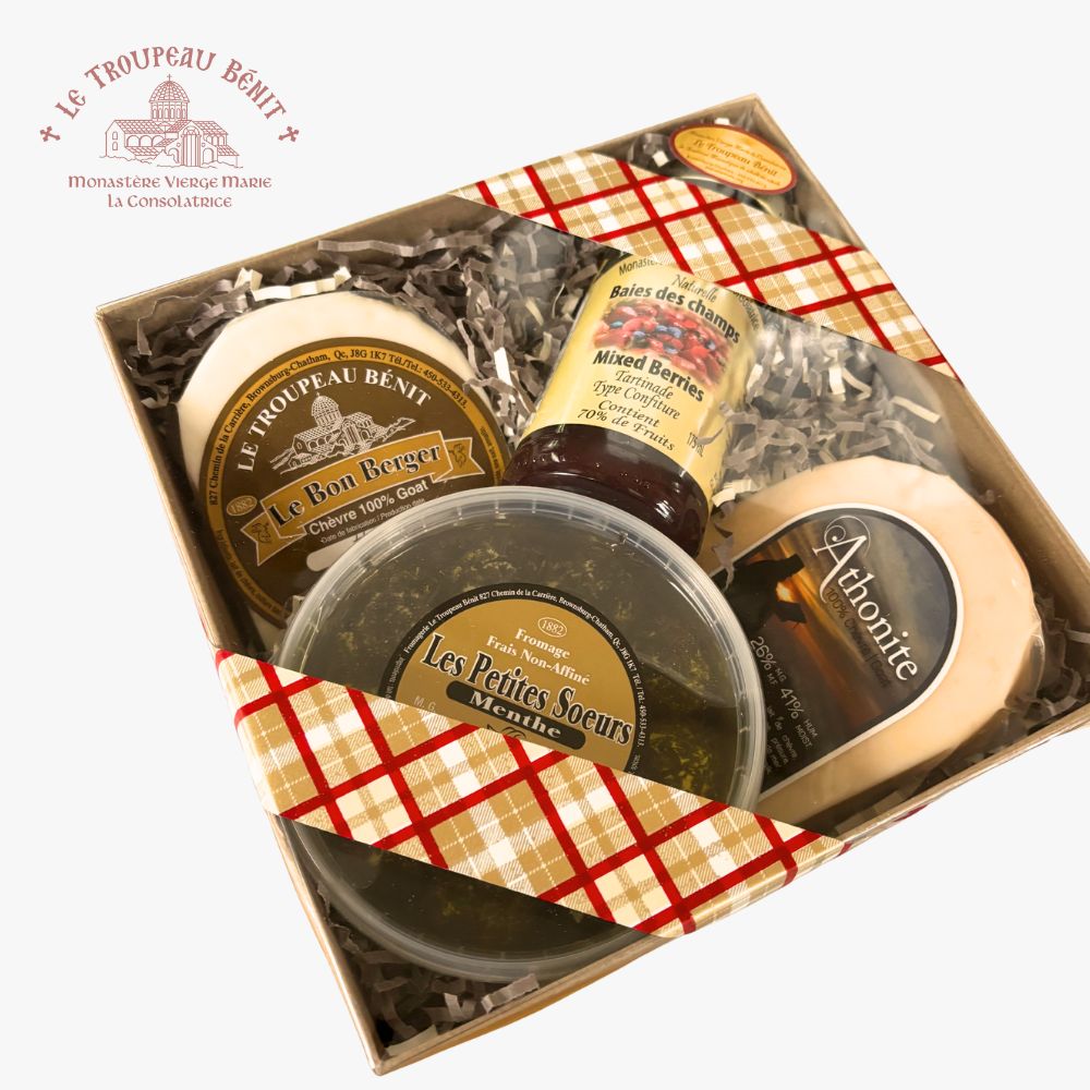 A gift box of gourmet cheeses and spreads from Le Troupeau Bénit, featuring Le Bon Berger cheese, Athonite, Les Petites Soeurs cheese, and mixed berries jam, arranged in a kraft box with a red and beige checkered ribbon on a white background.