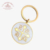 Gold keychain with engraved IC XC NI KA and Cross symbols on a white background with 'Troupeau Benit' logo branding