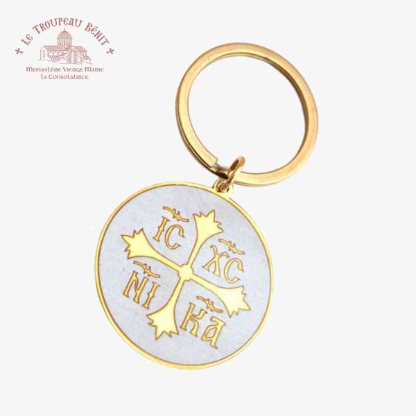 Gold keychain with engraved IC XC NI KA and Cross symbols on a white background with 'Troupeau Benit' logo branding