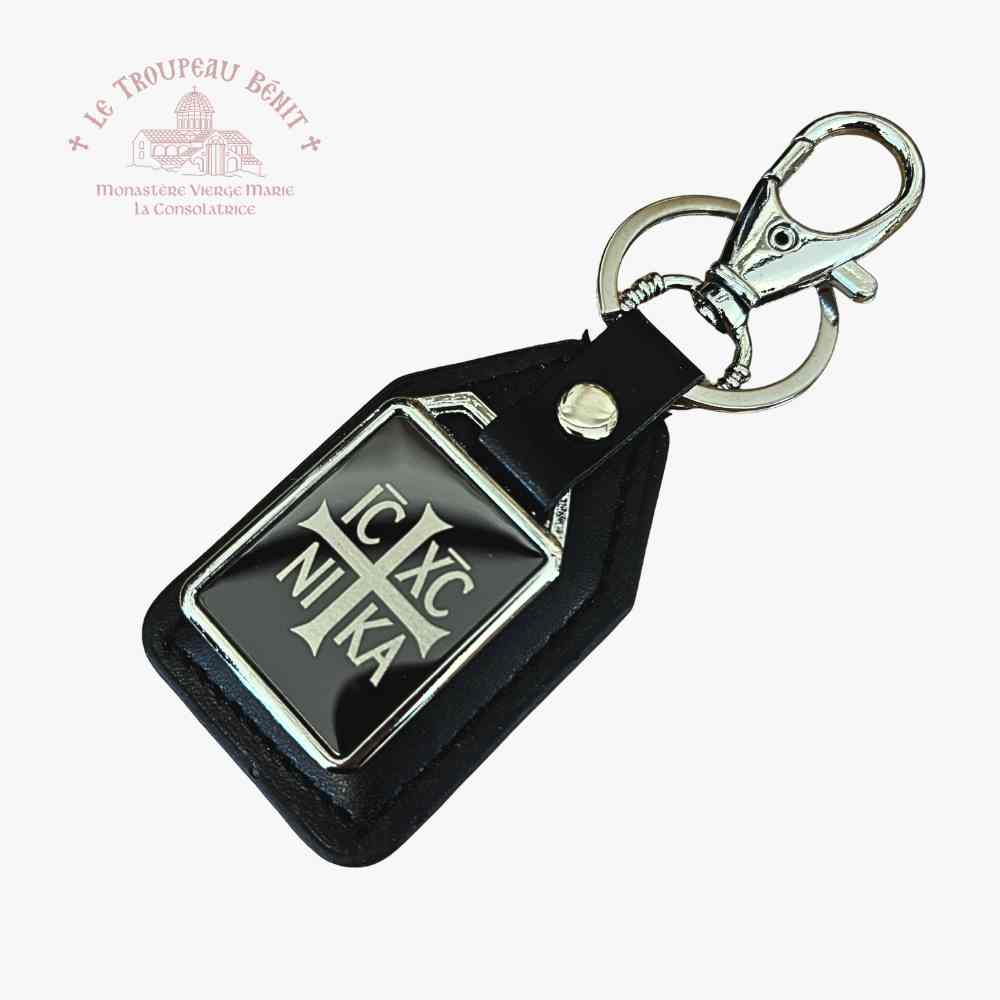 Black leather keychain with metal emblem IC XC NIKA on a white background