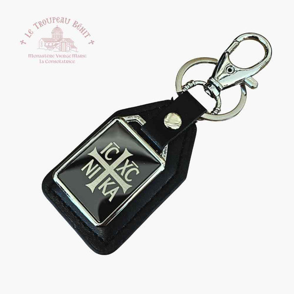 Black leather keychain with metal emblem IC XC NIKA on a white background