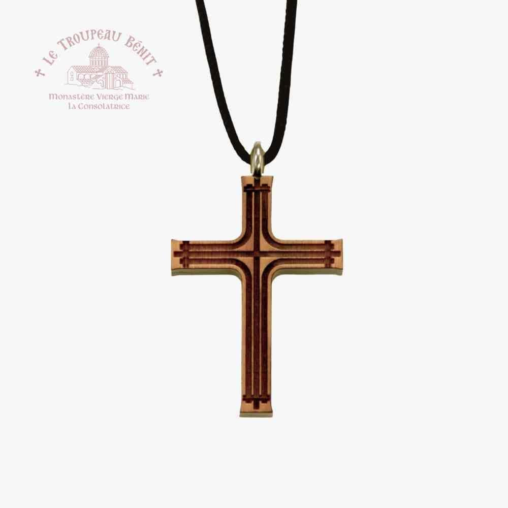 Wooden cross pendant on a black cord with a white background with 'Troupeau Benit' logo branding