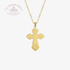 Gold cross pendant on a chain with 'Le Troupeau Bénit' logo in the corner.