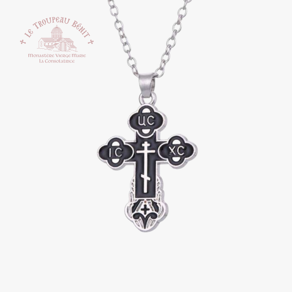 Silver cross pendant necklace on a white background with 'Le Troupeau Bénit' logo.