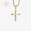 Gold and silver cross pendant on a white background with Le Troupeau Benit logo.