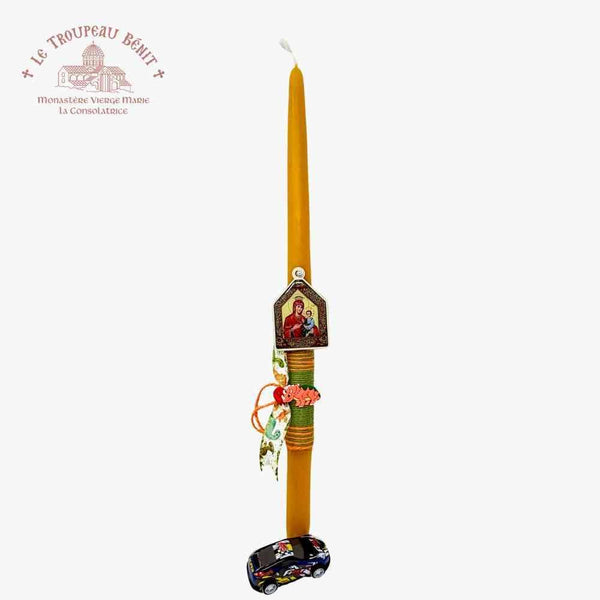 Taper candle with Orthodox icon of the Mother of God and toy car on a white background, featuring Le Troupeau Benit logo.
