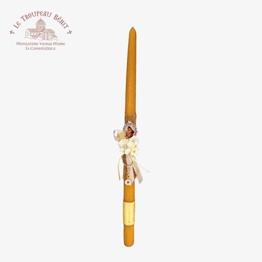 Decorative candle with floral arrangement on a white background, featuring Le Troupeau Bénit logo.