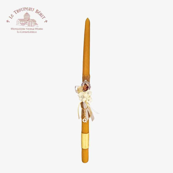 Decorative candle with floral arrangement on a white background, featuring Le Troupeau Bénit logo.