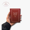 Hand holding a red prayer book titled 'Prayer Book and Psalms' with a visible 'Troupeau Benit' brand logo on a white background.