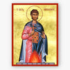 A religious icon painting of Saint Aimilianos on a gold background with a red border, shown against a light gray wall.