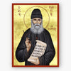 Icon of Saint Paisios the Athonite holding a book with Greek text on a gold background