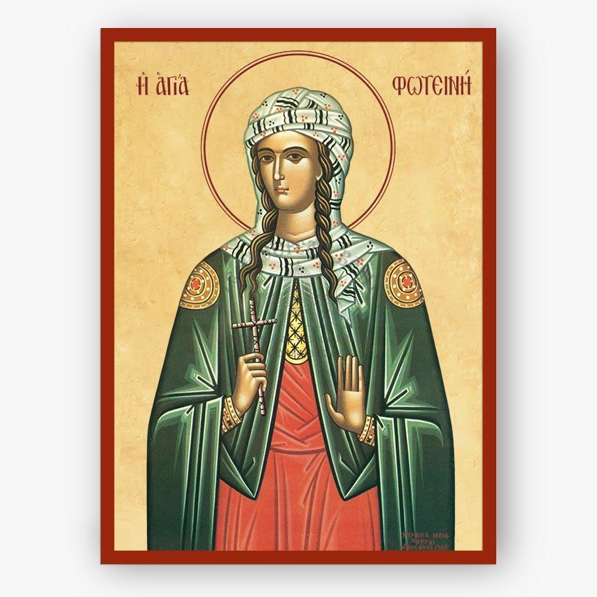 A religious icon print of Saint Fotini, depicted in a green cloak and red dress with a beige background and red border, shown against a light gray wall.