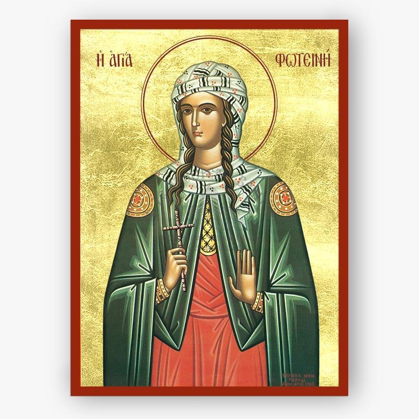 A religious icon print of Saint Fotini, depicted in a green cloak and red dress with a gold background and red border, shown against a light gray wall.