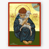 A religious icon print depicting Saint Spyridon holding a white lamb, with a gold background, red border, and dark green lower section. The icon is shown against a light gray background.