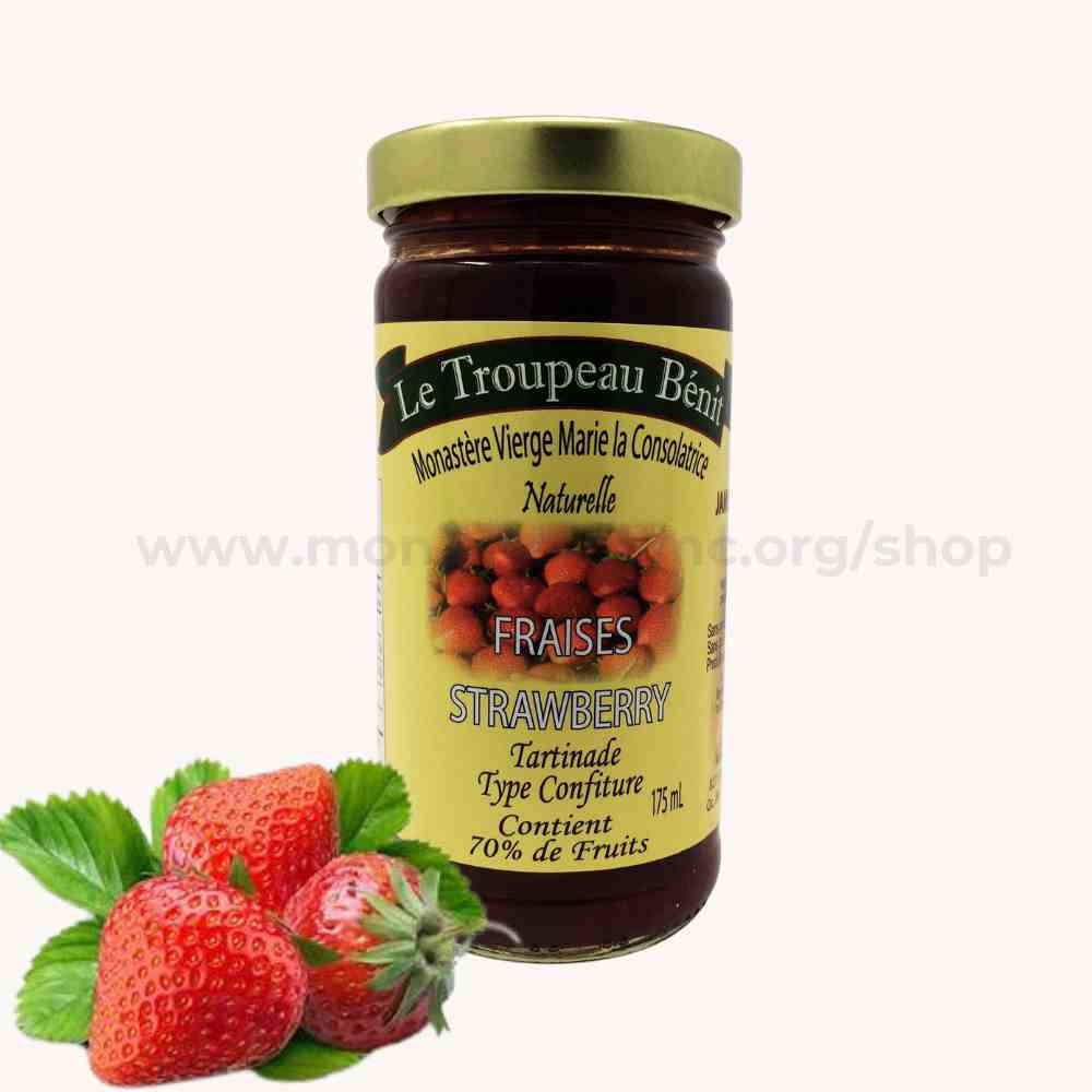 Jar of strawberry jam with a label Le Troupeau Benit and strawberries on a white background