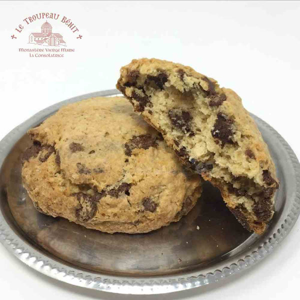 Chocolate chip cookie on a silver plate with 'Le Troupeau Benit' logo.
